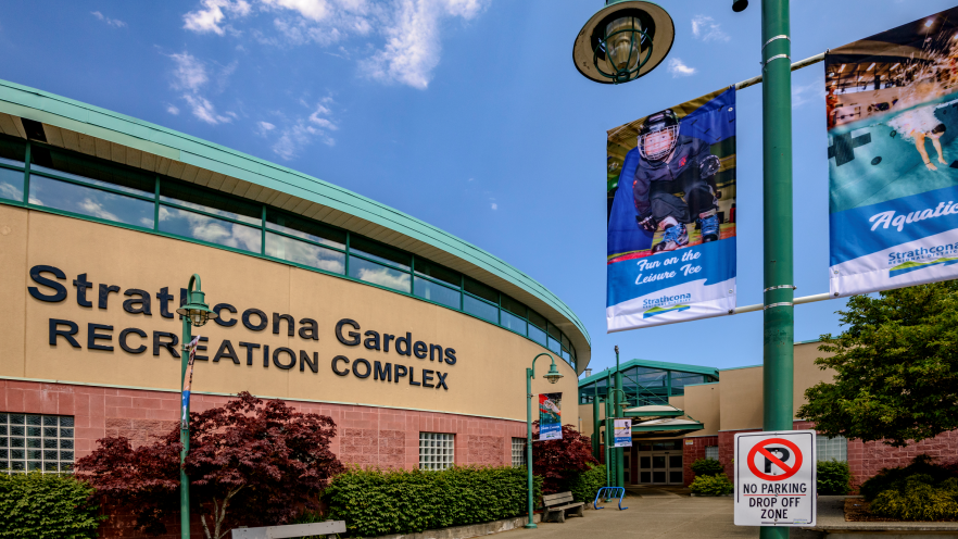 Strathcona Gardens Recreation Complex exterior with blue sky and lamppost banners.
