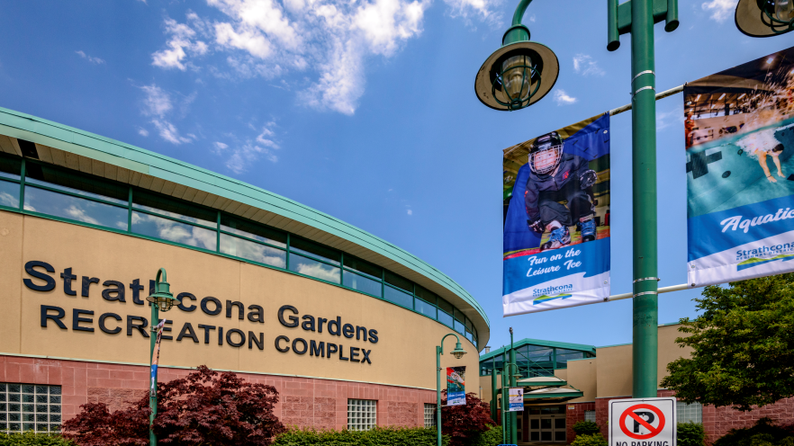 Stratcona Gardens Recreation Complex exterior with banners and clear blue sky.