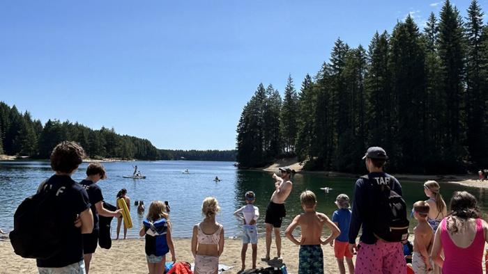 Staff and children standing on McIvor Lake beach