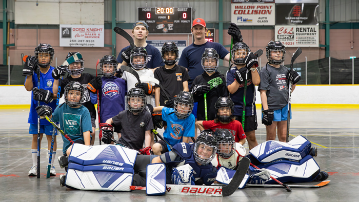 Group of kids on arena dry floor playing after school ball hockey