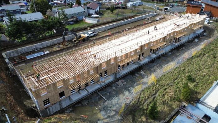 Construction site of a building with framing in progress, surrounded by residential areas.