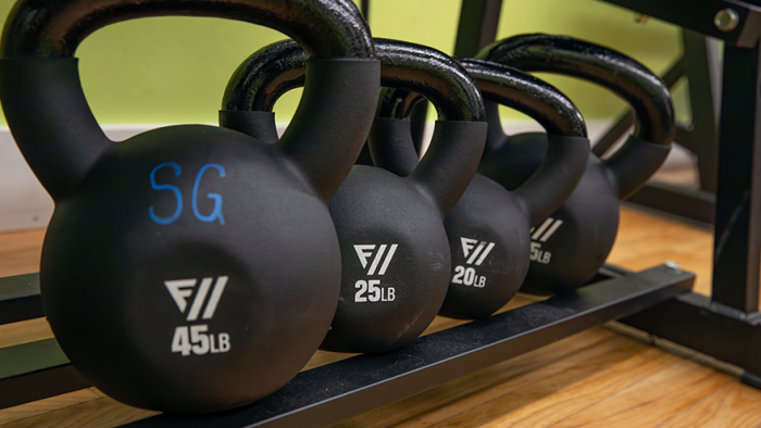 Four kettlebell weights on a rack