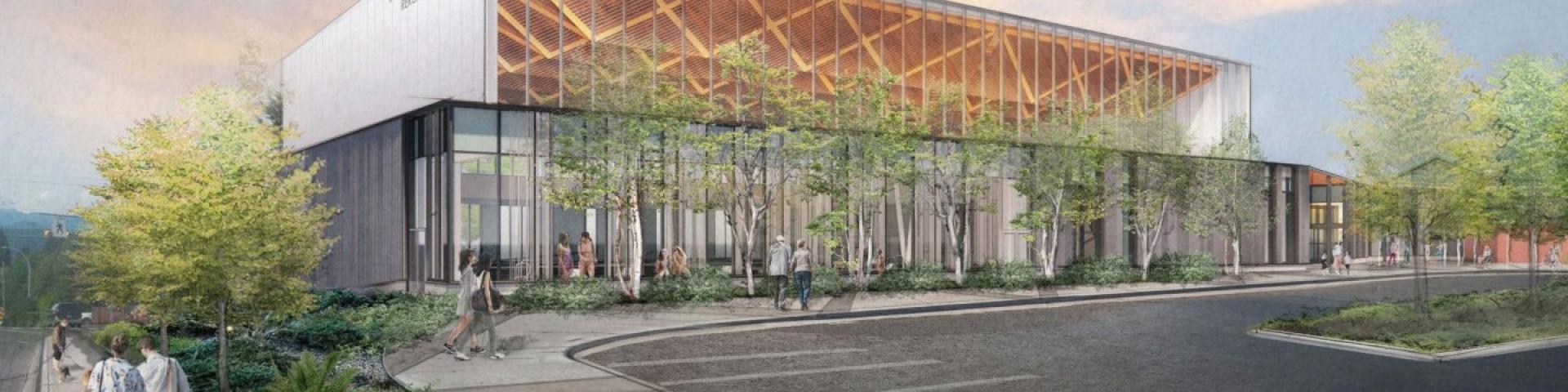 Modern building with glass walls, trees, and a sunset sky.