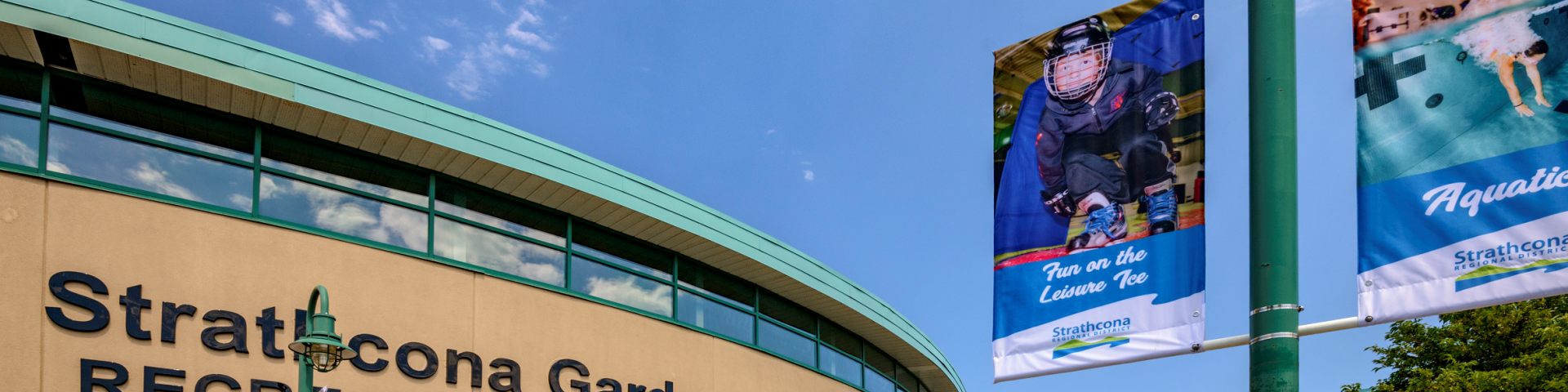 Stratcona Gardens Recreation Complex exterior with banners and clear blue sky.