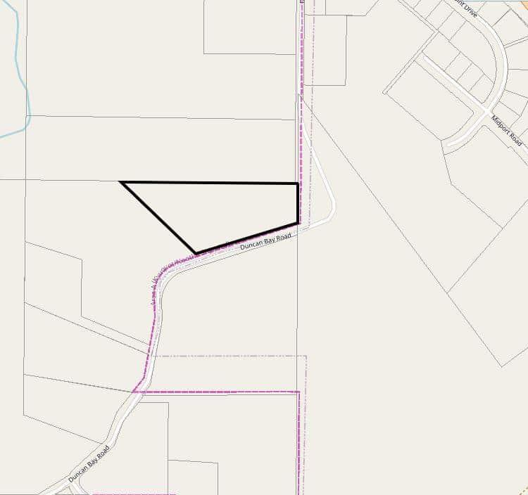 Map with outlined triangular plot and surrounding roads.