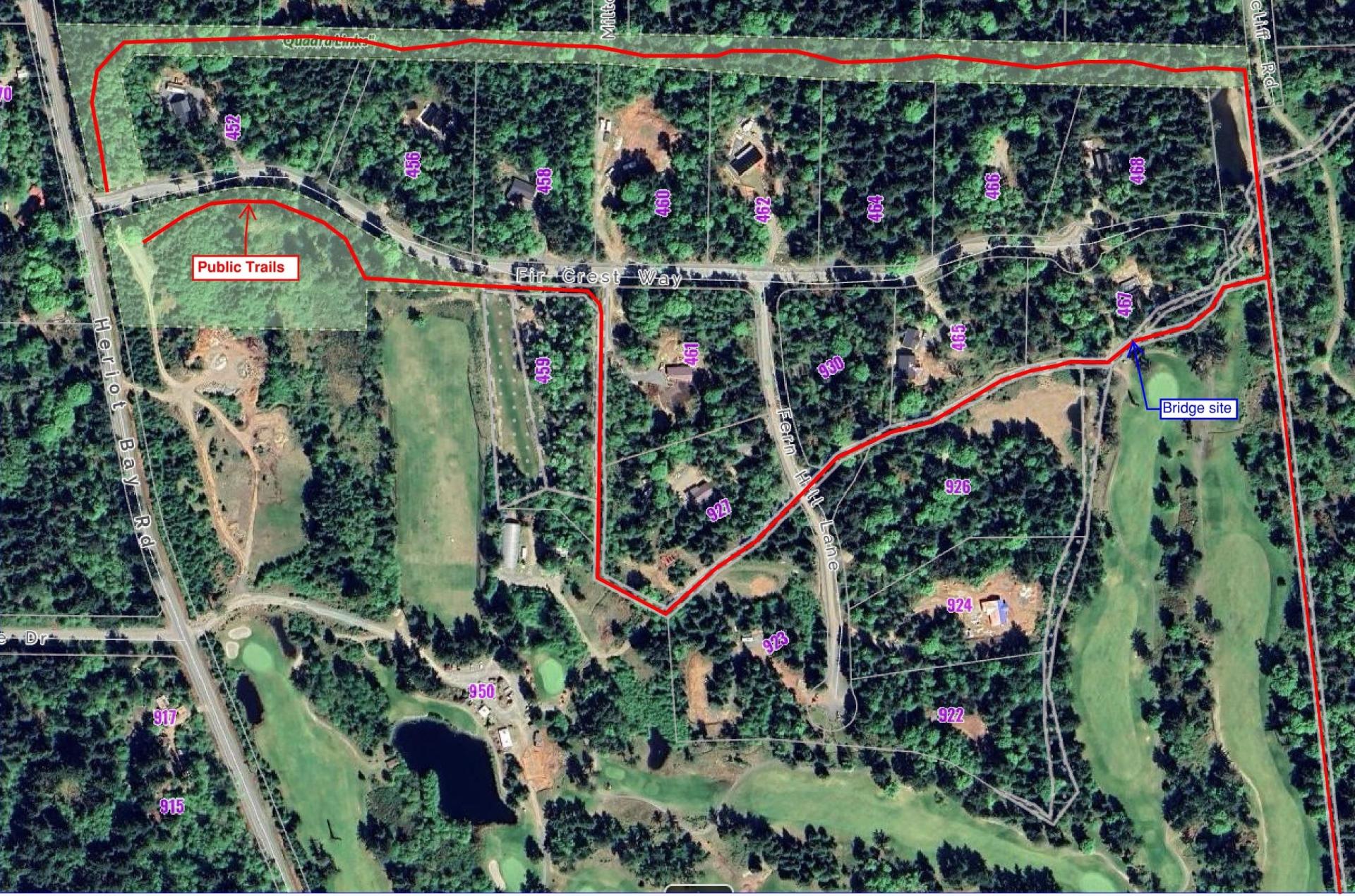 Aerial view of wooded area with roads and open fields outlined in red.