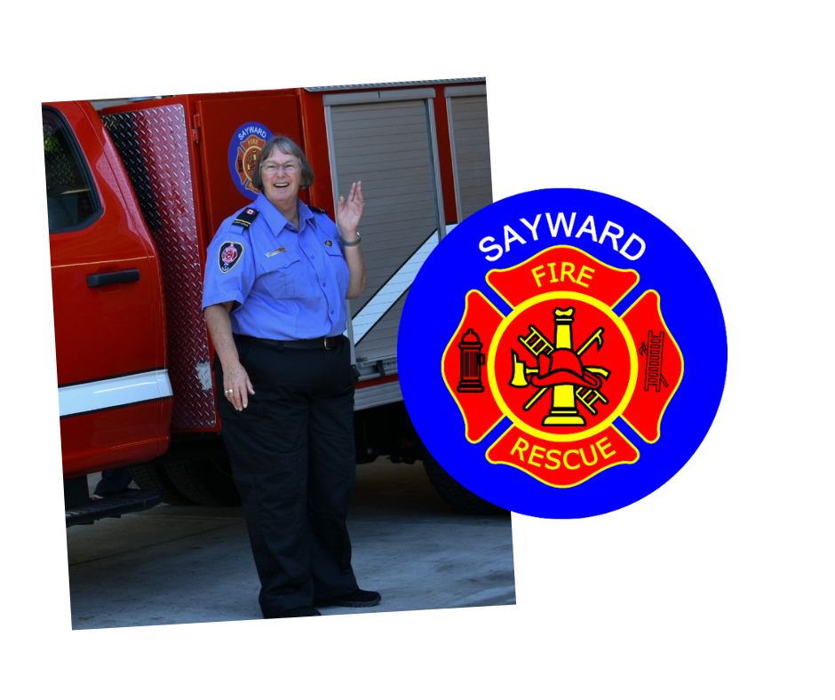 A smiling firefighter in uniform waves beside a fire truck, with a fire department logo nearby.
